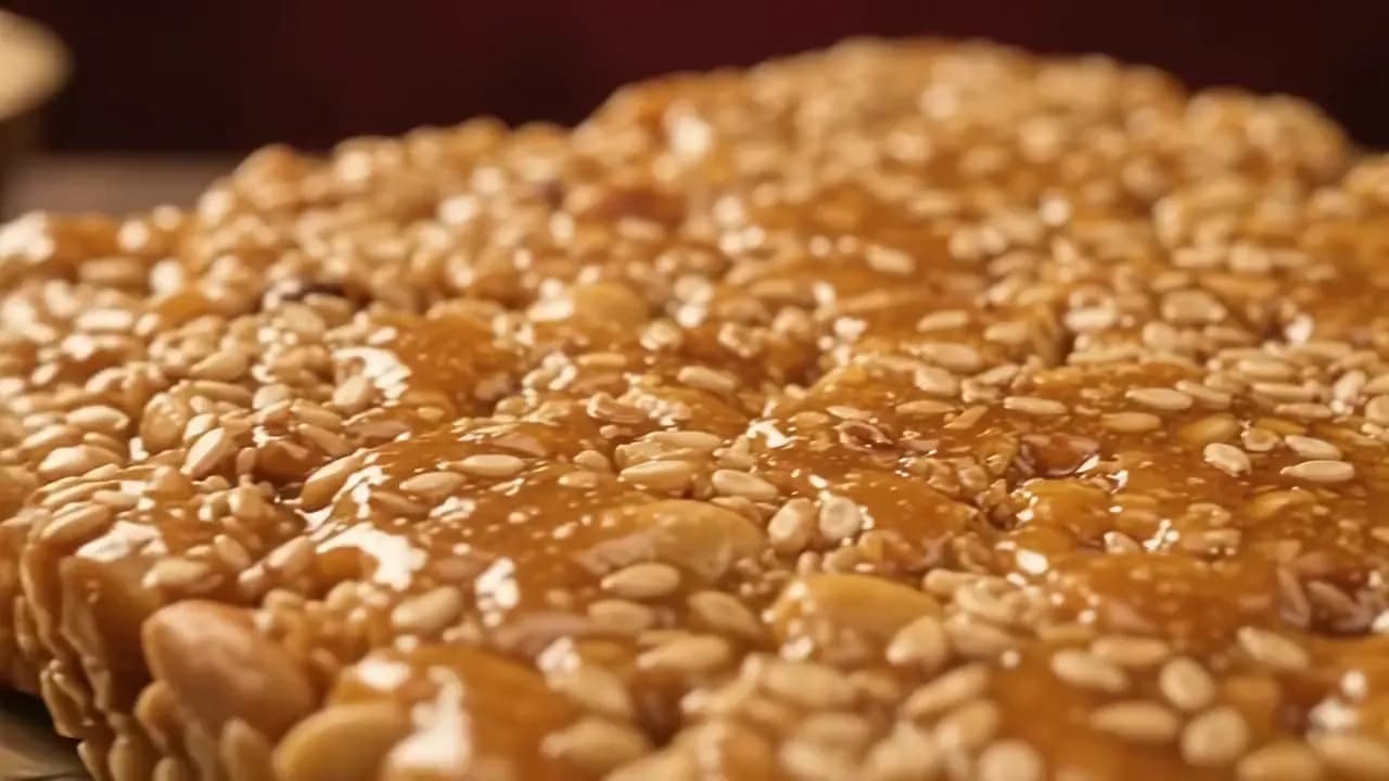 Close-up of glistening sesame and jaggery gachak being broken